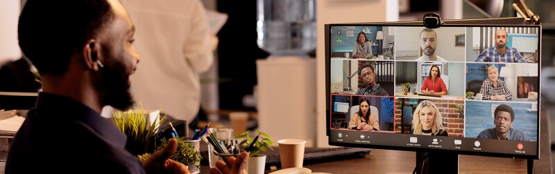 Man in office attending videoconference with remote co-workers