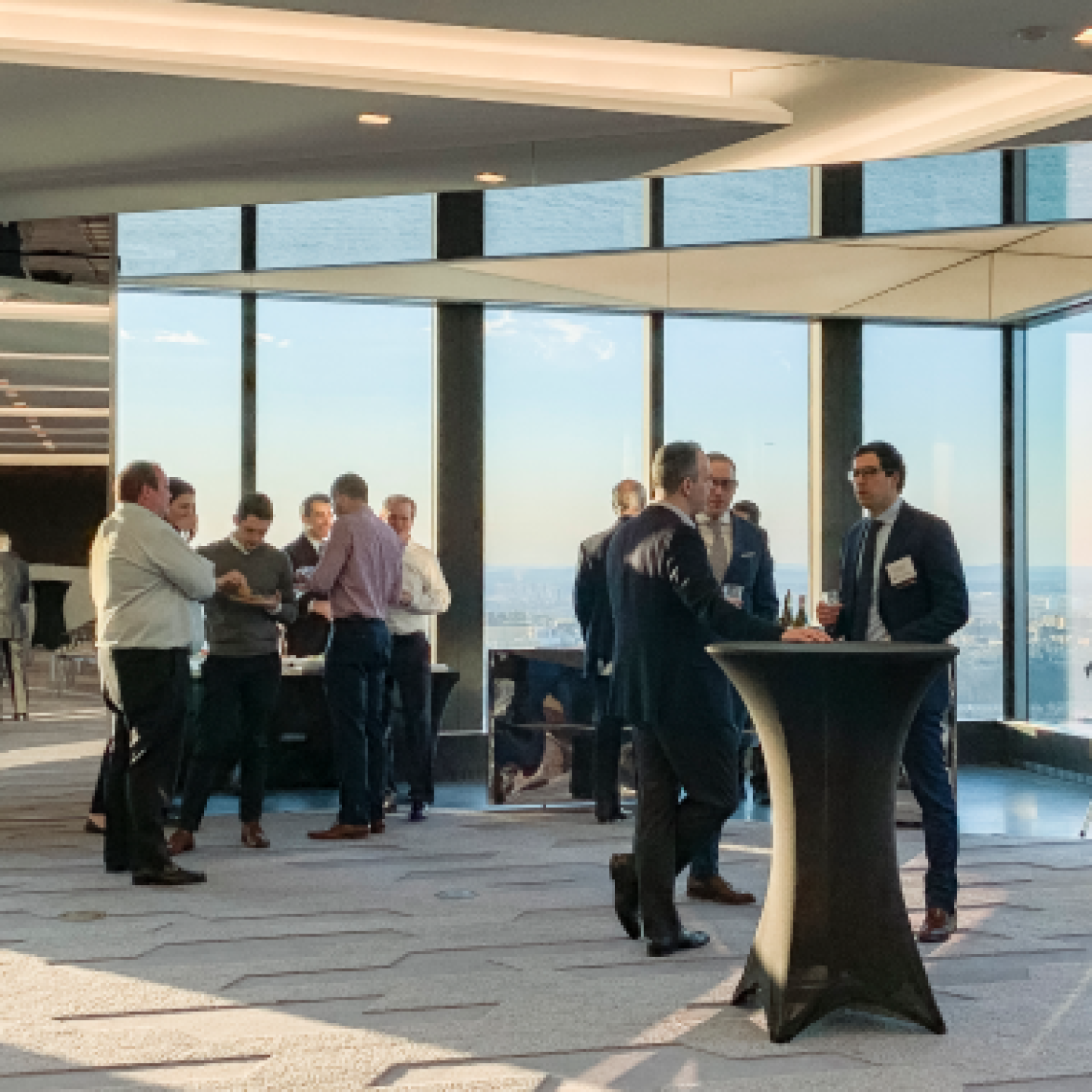 A group of real estate professionals is gathering in a high-rise restaurant.
