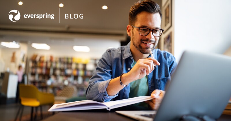 Smiling man sitting in office and working on laptop