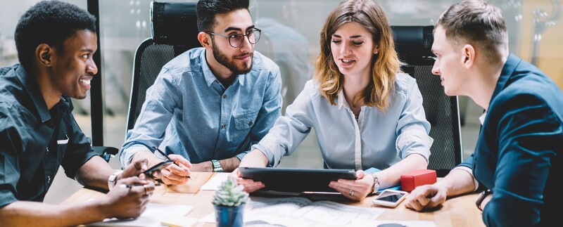 Diverse group professionals sitting around a large conference table