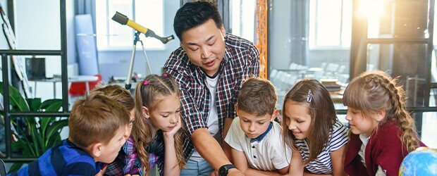 Teacher instructs his students, helps work through a project