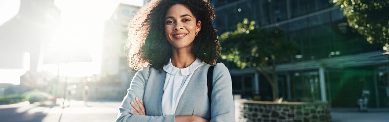 Confident social worker standing with arms crossed on a city street