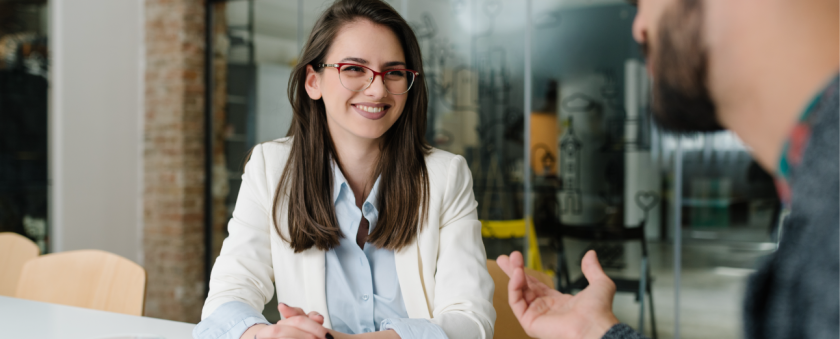 Professional woman with glasses discussing human resource jobs in the sports industry.
