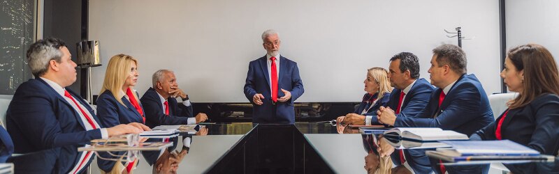 Senior business people discussing at modern office meeting room. 70s company leader talking to his employees.