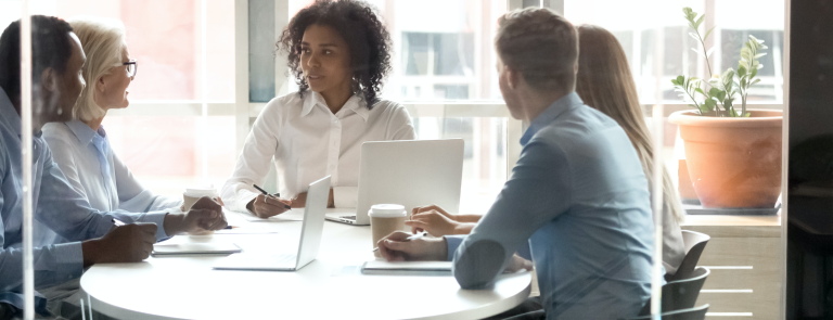 HR professionals sit around a table in a meeting