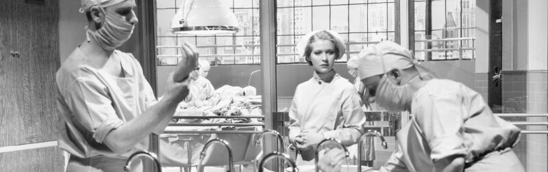 Vintage photo of two surgeons and a nurse in the scrub room preparing for an operation.