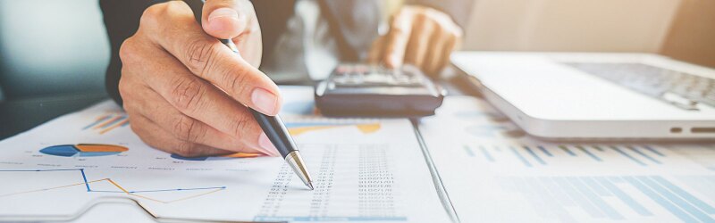 Business professional working with laptop and calculator