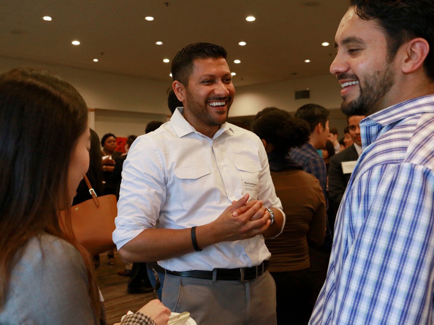 Three people talking at a networking event