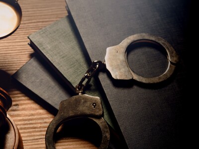 Gavel, scales of justice. handcuffs, and law book sitting on a table