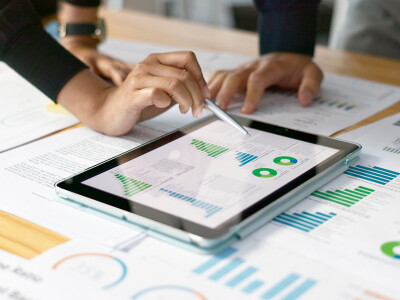 Marketing professionals reviewing digital analytics data on a tablet and printed reports