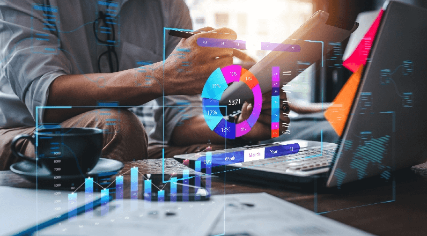 Man seated at coffee table with laptop, overlaid with graphs and charts