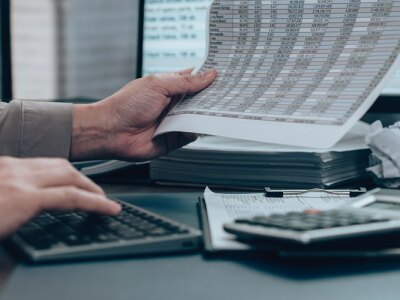 Investors reviewing financial statements for data cost, balance, profit and currency.