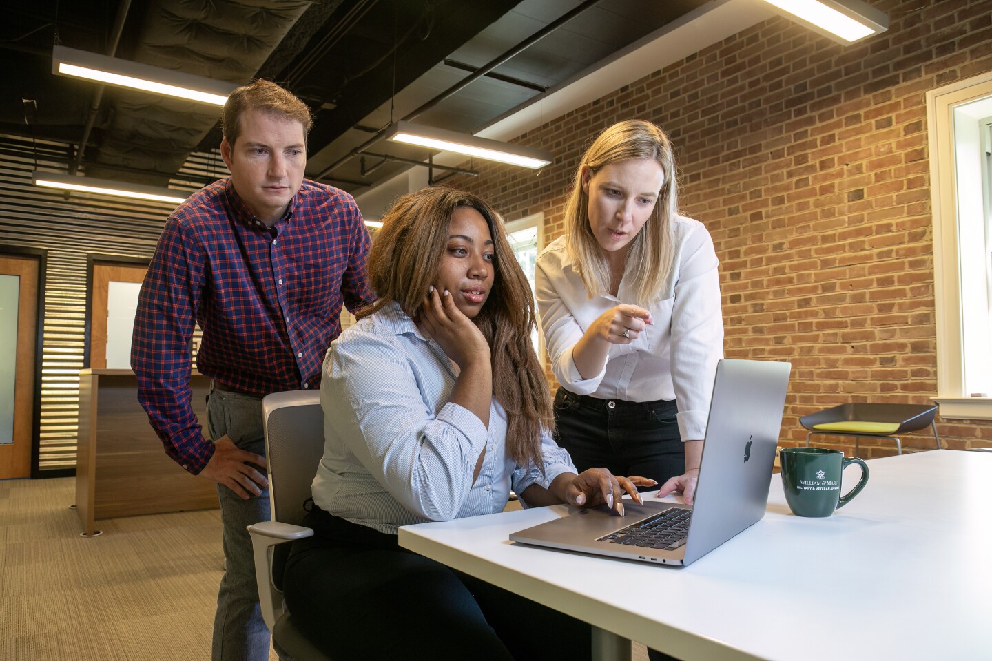 Team of workers looking on laptop