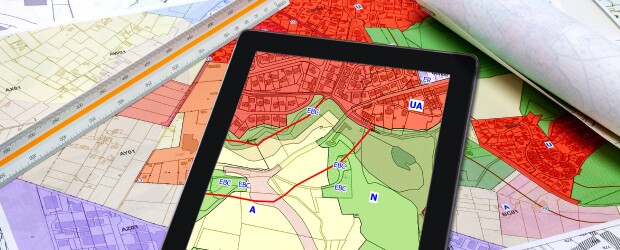 Maps and a tablet screen showing urban and rural landscapes