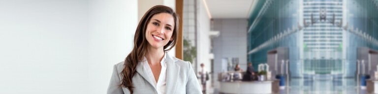 Friendly professional stands in atrium of university