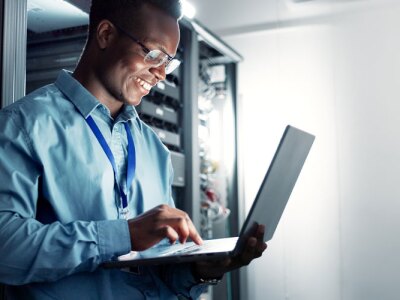 Professional Cybersecurity Analyst reviews server metrics in a data center.