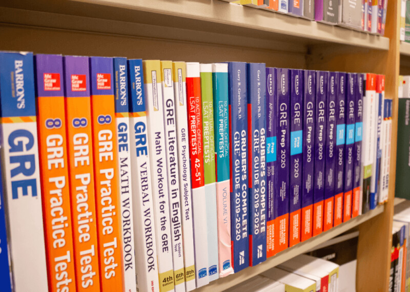 Shelf of GRE prep workbooks on a shelf