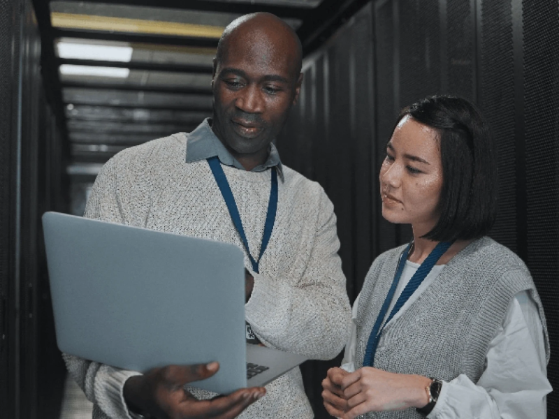 Male and female diverse students looking at a laptop