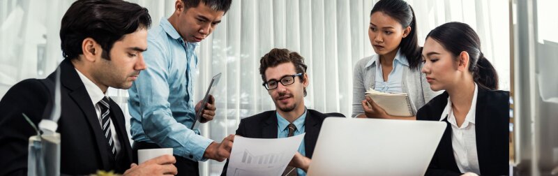 Diverse group of business analyst team analyzing financial data report paper on office table.