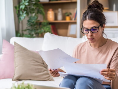 Seated at home, a nursing student reviews financial paperwork