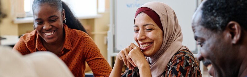 Divers group sitting at table in a community space