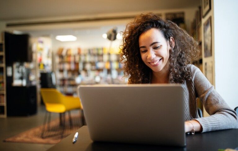 Young beautiful student girl working, learning in college library