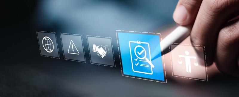 Hand holding stylus selects an icon on a digital screen.