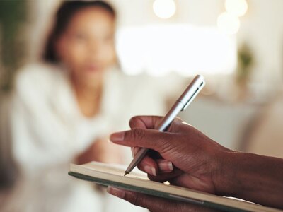 mental health professional taking notes during session with patient