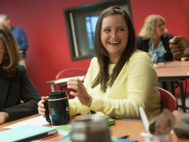 Two women working together and smiling at a table