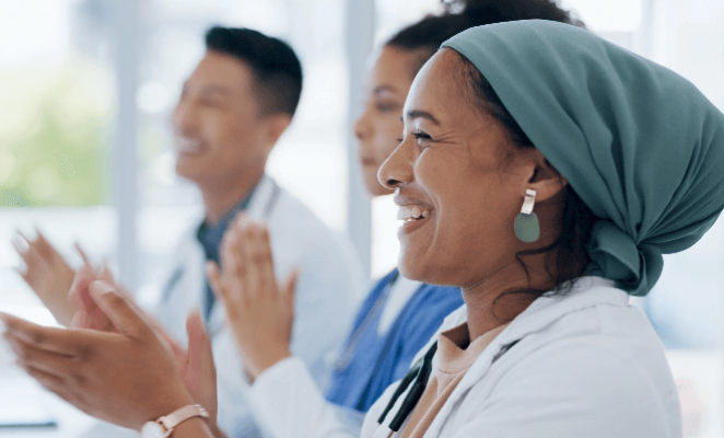 Three doctors looking forward and applauding