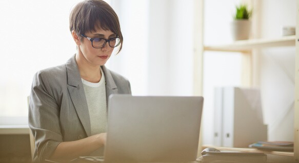 Woman works on a laptop in home office