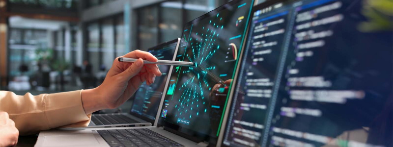 A woman's hand holding a stylus—pointing it at the center of a laptop screen.