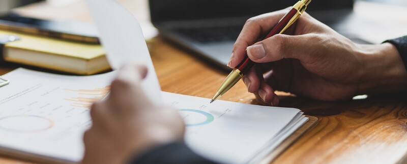 Man working on paperwork, analyzing financial statements