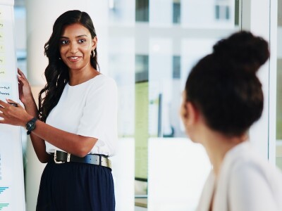 An executive uses data visualization to present information to colleagues in a meeting.