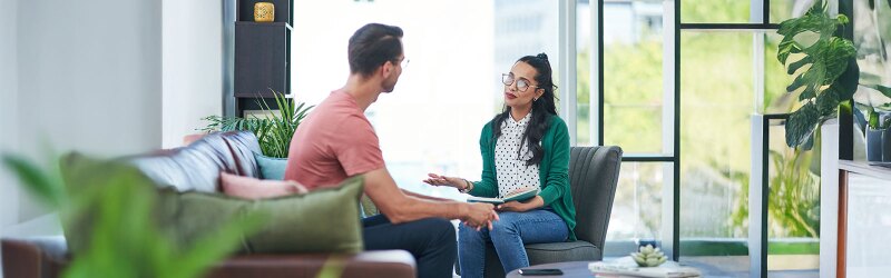 female mental health professional and client sitting in a green room in session