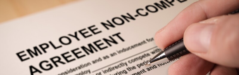 Man signing an employee Non-compete agreement
