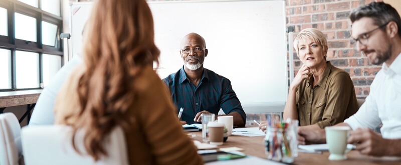 Group of five diverse people meeting in a boardroom