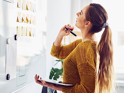 Instructional designer in office using whiteboard and tablet