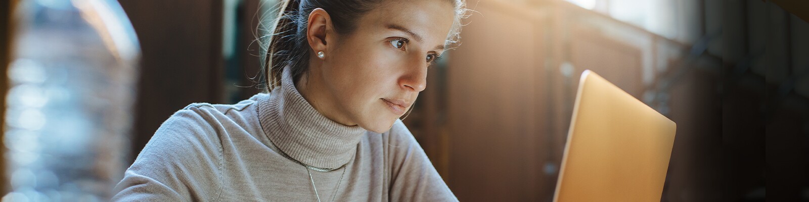 woman in beige turtle neck sweater smiling