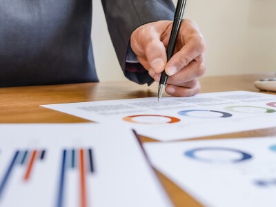 Portfolio manager analyzing financial charts and graphs on paper