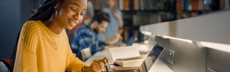 Woman focused on her laptop in a library