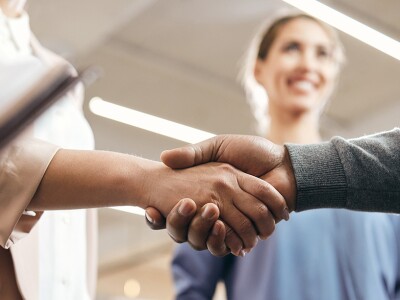 Close-up of co-workers handshaking after resolving a conflict