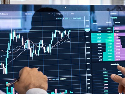 Two men analyzing data on a computer screen.