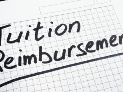 Open notebook with "Tuition Reimbursement" written in black marker