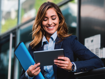 woman smiling looking down at her tablet