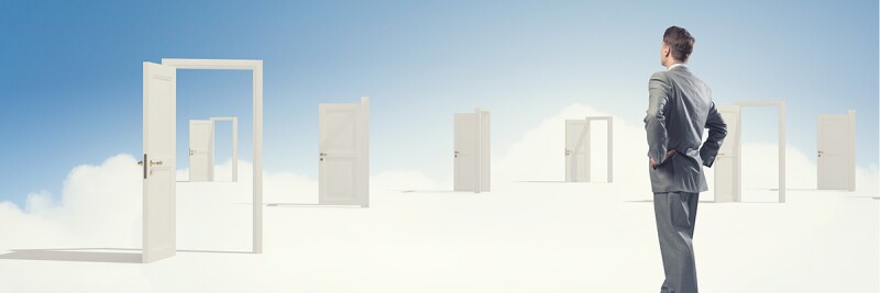 Man looking at open doors in dreamy cloud setting.