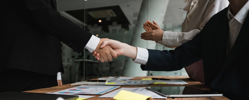 Two business professionals sealing a merger deal with a handshake