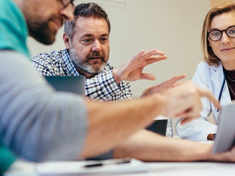 IT manager walking two doctors through user experience on a tablet