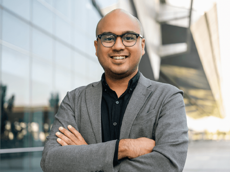 Smiling man in blazer with arms crossed