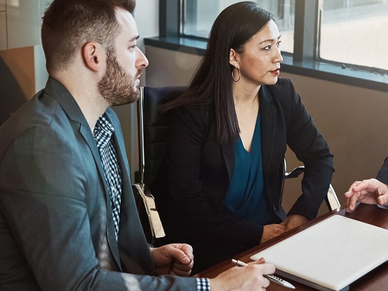 Business professionals in a meeting discussing compliance policies and organizational risk management.